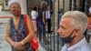 Personas esperan en las afueras de un banco para cobrar la pensión