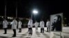 Médicos cubanos posan al lado de un cuadro de Fidel Castro el 10 de febrero de 2023. (Reuters/Alexandre Meneghini).