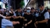 La policía detiene a una mujer en el Parque Victoria, en Hong Kong, en el aniversario 34 de la masacre de Tiananmén. (AP/Louise Delmotte).
