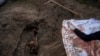 Un gato sentado sobre la tumba de Lyudmyla Kononuchenko, que fue enterrada el viernes 15 de abril de 2022, en Irpin, en las afueras de Kiev.