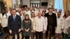 El presidente de la Región de Calabria Roberto Occhiuto y la embajadora cubana Mirta Granda Averhoff posan con los doctores cubanos.