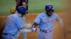 El cubano Adolis García (derecha) celebra junto a Jonah Heim (izquierda) luego de anotar la carrera de la ventaja en la octava entrada del juego ante los Guardianes de Cleveland, en Arlington, Texas. Domingo 16 de julio de 2023. (AP Foto/Gareth Patterson).