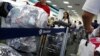 Cubanos residentes en EEUU cargados de equipaje hacen fila en el Aeropuerto Internacional de Miami para viajar a la isla. REUTERS/Carlos Barria/Archivo