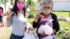 Roxana García Lorenzo, una de las promotoras de la iniciativa, entrega la ayuda a la familiar de tres de los detenidos.