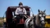 Una cochero se protege del coronavirus con una máscara, en La Habana. (AP/Ramon Espinosa)