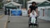 Steve Oliveros conduce a su madre en silla de ruedas de vuelta a Colombia tras serle negado el paso en la frontera para entrar a Venezuela.
