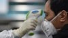 Un miembro de los servicios médicos chequea la temperatura de un paciente en un hospital de Wuhan, epicentro de la epidemia del coronavirus, el 25 de enero del 2020.