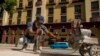 Takechy Hernández, quien trabaja para el contratista Watt Electric, puliendo el piso del Paseo del Prado en La Habana, el 26 de enero de 2022. (AP Photo/Ismael Francisco).