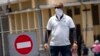 Un hombre con mascarilla frente a una calle cerrada al tráfico vehicular en La Habana. (AP/Ramon Espinosa)