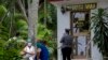 Varias personas permanecen afuera de una oficina de la Western Union, en el Vedado, La Habana. (AP/Ismael Francisco)