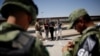 Un agente del Instituto Nacional de Inmigración (INM) de México habla con cubanos detenidos por la Guardia Nacional mientras intentaban cruzar ilegalmente la frontera en Ciudad Juárez el 21 de junio de 2019 (Archivo).