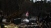 Una mujer cuelga un cartel de prohibido el paso en el sitio de una casa destruida por los incendios forestales de Maui en Kula, Hawai, el 13 de agosto de 2023.