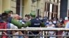 Cubanos se aglomeran en un mercado de La Habana, bajo la vigilancia de agentes de la policía, para comprar alimentos, el 12 de abril del 2020.