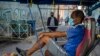 Un taxista en bicicleta espera clientes afuera de una vivienda, en La Habana, donde la policía controla el acceso a un vecindario. (AP/Ramon Espinosa)