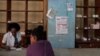 Una mujer compra medicamentos en una farmacia junto a un cartel que anuncia las próximas elecciones legislativas, en el centro de La Habana, Cuba, 17 de marzo de 2023. REUTERS/Alexandre Meneghini