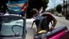 Cuentapropista desinfecta su carro en La Habana ante el coronavirus