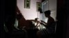 Una familia juega a las cartas mientras usa una lámpara recargable para iluminar su casa durante un corte de energía en Bejucal, provincia de Mayabeque, Cuba, 8 de febrero de 2024. REUTERS/Norlys Pérez