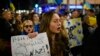 Una mujer sostiene un cartel que dice "Fuera de Ucrania, nazis rusos" durante una manifestación para apoyar a Ucrania.