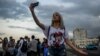 Una joven youtuber cubana graba un video en el Malecón habanero.