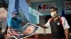 Dos cubanos decoran un muro con la imagen del fallecido dictador Fidel Castro, en vísperas del 1ro de mayo del 2020. (Yamil Lage/AFP/Archivo).