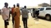 Oficiales de seguridad y civiles junto al auto donde secuestraron a los médicos cubanos en Mandera, Kenia.