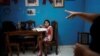 Liz Mariam recibe instrucciones de su mamá para hacer las clases a distancia. COVID-19. REUTERS/Alexandre Meneghini