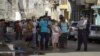 La policía controla la cola en una de las nuevas tiendas en dólares. (Adalberto ROQUE / AFP)