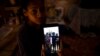 María Carla Milán Ramos muestra una foto en su teléfono de su esposo y sus hermanos, todos en prisión por participar en las protestas del 11 de julio del 2021.